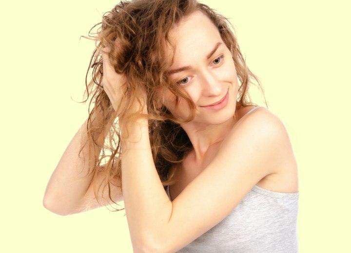 Young woman taking care of her permed hair
