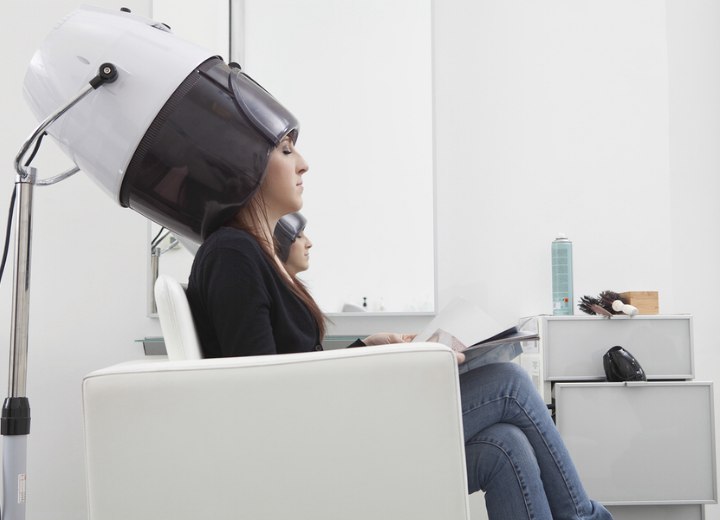 Hair salon client under a hood dryer