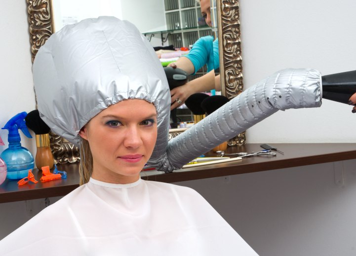 Hair salon customer under a drying cap
