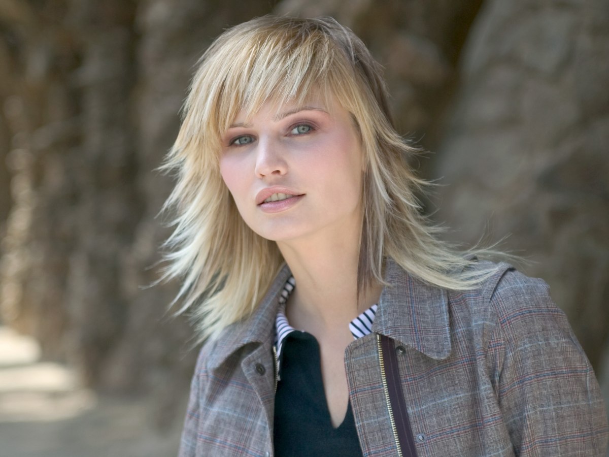 Long layered haircut, fringed at angles to frame the face