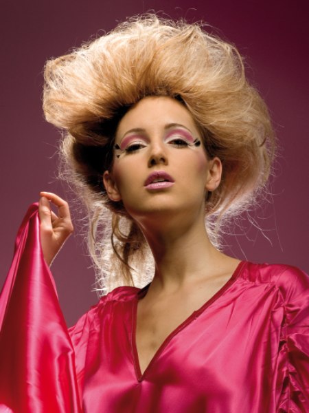 Dress in flowing satin and teased hair pulled together in a loose up do