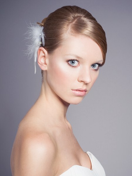 Updo with a chignon and a feathery hair accent