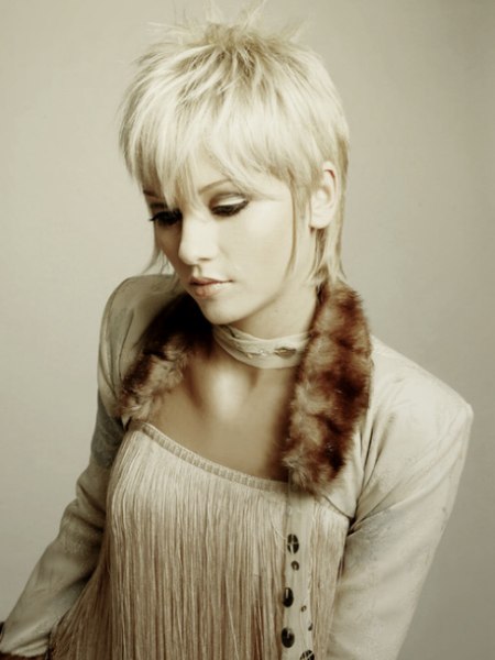Pixie haircut with an elongated nape and sideburn tendrils