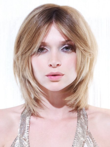 Medium length haircut with a round form and blonde shades