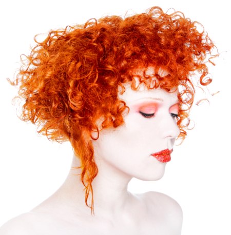 Very curly hair with a fiery coppery metallic color