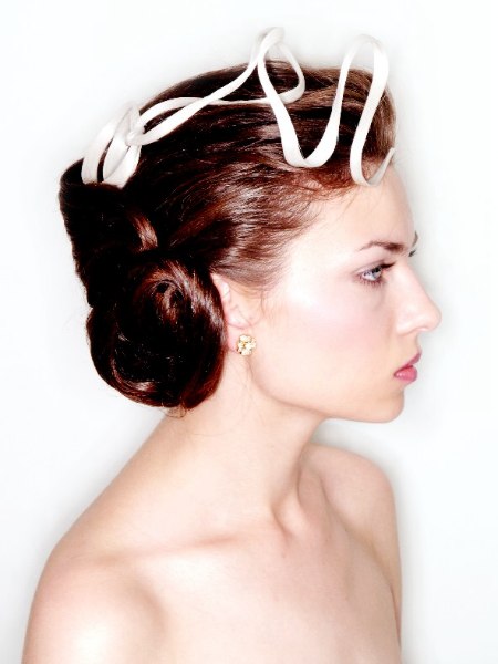 Classic up do with a sleek roll in the back and a satin ribbon