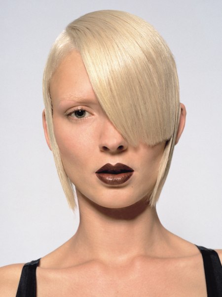 Neat and flat haircut based on a graphical shape with asymmetrical bangs