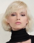 Short blonde bob with softness and feathered bangs