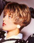 Short 1980s hairstyle with visible earlobes and thin bangs