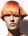 Short blunt cut coppery hair with a sharp edge
