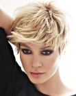 Blonde pixie cut with the hair styled towards the face