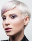 Platinum blonde pixie haircut with pink color accents