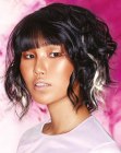 Curly black bob with a shorter back and white streaks