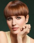 Copper bowl cut hair with full bangs and a glossy surface