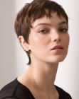 Very short pixie cut with nape length and curled bangs