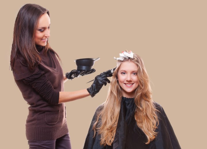 Female cosmetologist coloring hair