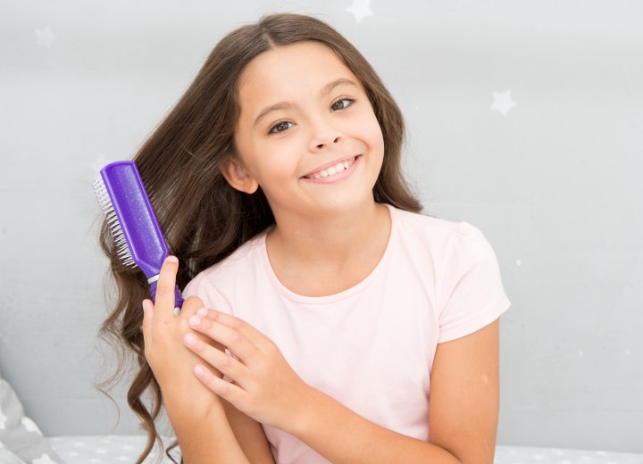 Young girl brushing her own long hair