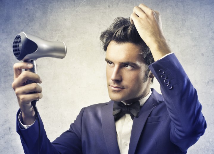 Man who is styling his hair with a blow dryer