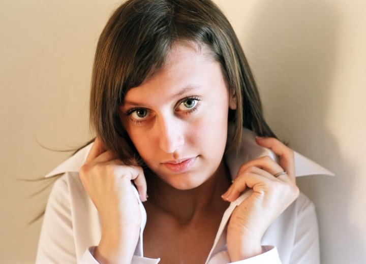 Woman who is wearing her buttoned shirt with the collar turned up