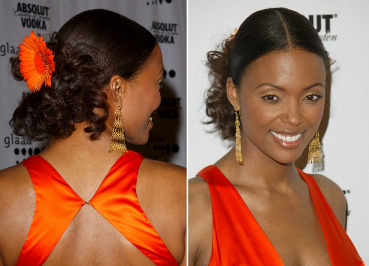 Aisha Tyler wearing a flower in her hair