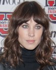 Alexa Chung sporting long ahir with bangs and loose curls