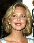 Arielle Kebbel wearing her blonde curly hair in an almost shoulder length style