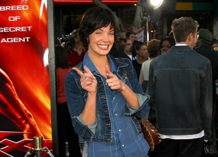 Ashley Scott wearing a short denim skirt and jacket