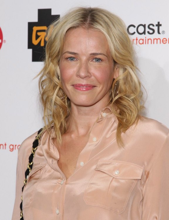 Chelsea Handler with her hair in curls and wearing a pink 