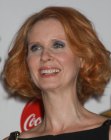 Cynthia Nixon wearing her red hair in a short bob with curls