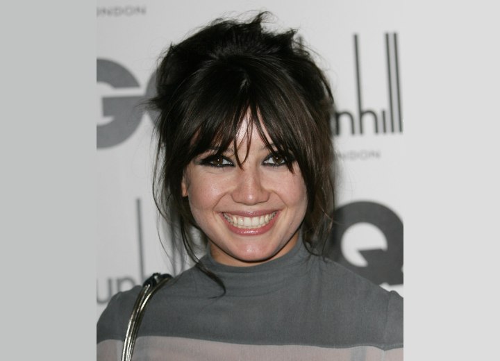 Daisy Lowe with her hair styled in a messy updo