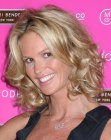 Elle MacPherson wearing medium length blonde hair with curls that bounce