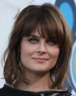 Emily Deschanel wearing her hair in a medium style with layers that covers her neck