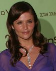Helena Christensen's long hairstyle with a sleek top and spiral curls