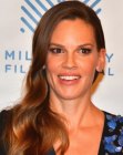 Hilary Swank with her long curled hair swept to one side