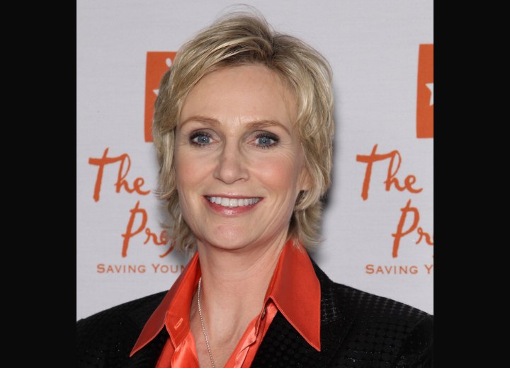 Jane Lynch - Short hairstyle and a silk orange blouse