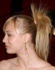 Kaley Cuoco wearing her hair in a ponytail with sprays of hair
