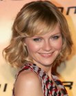 Kirsten Dunst sporting a medium length hairstyle with bouncing curls