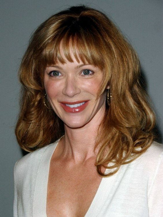 Lauren Holly with long hair styled to keep it bouncy for 