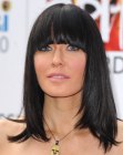 Linzi Stoppard's long hairstyle with heavy bangs and a sleek appearance