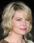 Michelle Williams wearing her blonde hair in a medium length style with side bangs