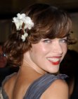 Milla Jovovich wearing a flower in her short hair