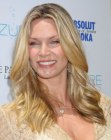 Natasha Henstridge's long hairstyle with sides that cuff around her face