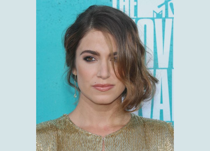 Nikki Reed wearing her hair styled up and swooped to one side