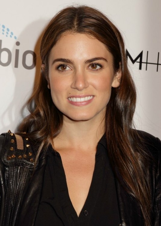 Nikki Reed with very long hair tucked behind both ears 