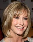 Olivia Newton John wearing her medium length hair in a bob with bangs