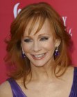 Redhead Reba McEntire with her hair cut into long layers