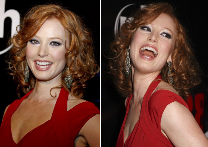 Alicia Witt with her red hair styled into curls