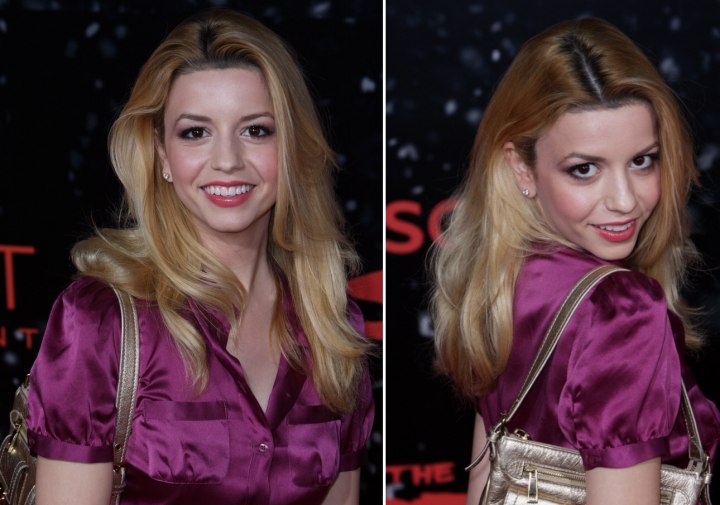 Masiela Lusha with a long airy hairstyle and wearing a silk blouse