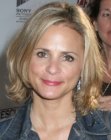 Amy Sedaris rocking a medium length hairstyle with a center part