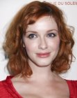 Christina Hendricks wearing her medium length red layered hair styled into curls